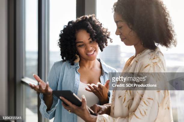 businesswomen use digital tablet together - encouragement stock pictures, royalty-free photos & images