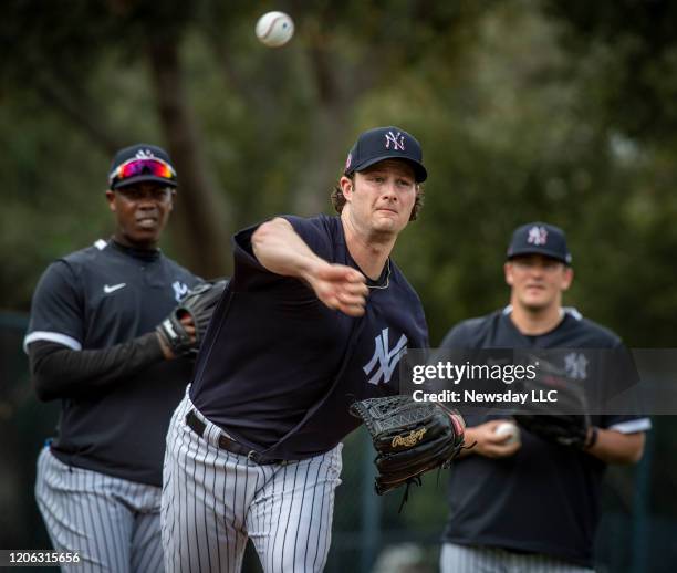 New York Yankees' pitcher Gerrit Cole fielding a hit ball while his teammates watch during spring training in Tampa, Florida on February 13, 2020.