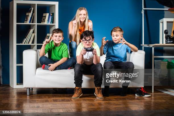 young gamers on sofa at home playing game on console and having fun - game four stockfoto's en -beelden