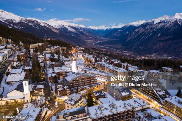 night view of the crans montana village and ski resort in canton valais in switzerland - crans montana stock pictures, royalty-free photos & images