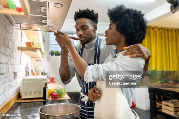 coppia che cucina insieme e uomo che assaggia la zuppa - soup home foto e immagini stock
