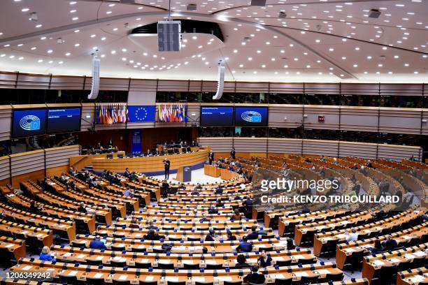 Members of the EU Parliament arrive and sit in an empty hemicycle at the beginning of the plenary session which is reduced to a single day due to the...