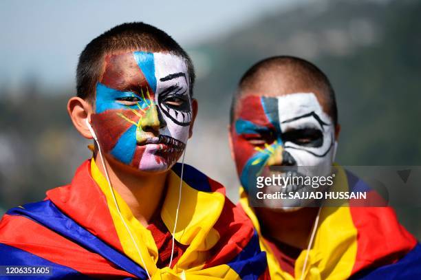 Tibetans living in exile pose for a picture as they take part in a protest march from McLeod Ganj to Dharamshala to mark the 61st anniversary of the...