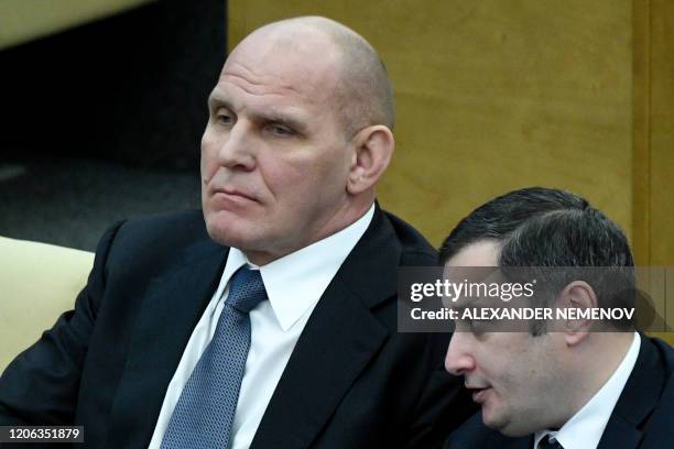 Lawmakers, including former wrestler Alexander Karelin, attend the second reading of the constitutional reform bill during a session of the State...