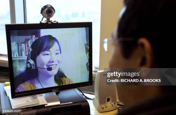 This picture shows a computer user in Hong Kong, 27 March 2007, looking at an image of online Mandarin teacher Lily Huang at her home on Hainan...