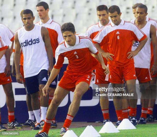 Le joueur brésilien Edmilson de l'Olympique Lyonnais effectue un exercice physique lors d'un entraînement, sous le regard de son compatriote Sonny...