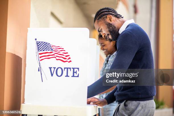 millenial black man and woman voting in der wahl - voting stock-fotos und bilder