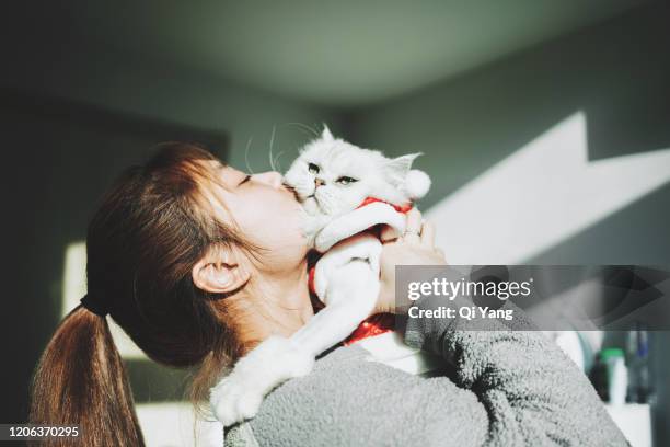 a young woman hugging her cat in the bedroom - cute asian woman stock pictures, royalty-free photos & images