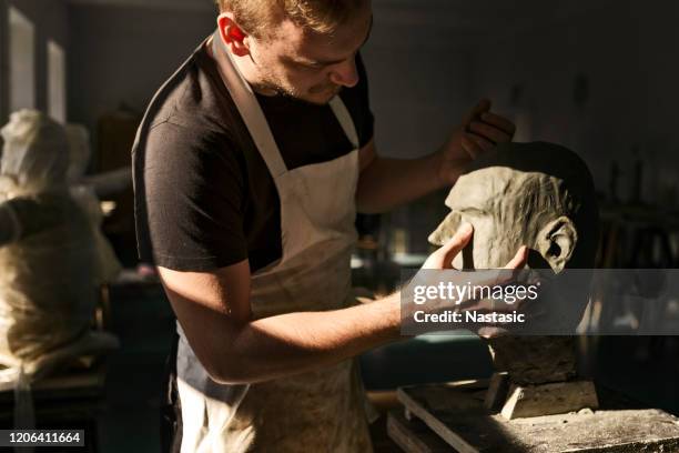 beeldhouwer die aan zijn beeldhouwwerk van het kleihoofd werkt - molding a shape stockfoto's en -beelden