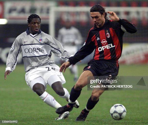 Le capitaine milanais Paolo Maldini est aux prises avec la défenseur parisien Aliou Cisse, le 14 février 2001 au stade San Siro à Milan, lors de la...