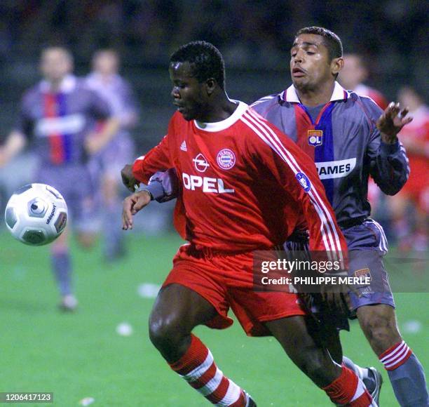 Le joueur de l'Olympique lyonnais Sony Anderson est à la lutte avec son adversaire allemand Samuel Kufour, le 06 mars 2001 au stade Gerland à Lyon,...