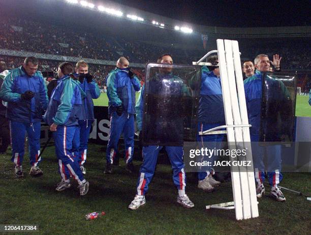 Les forces de l'ordre se protègent, le 13 mars 2001 au Parc des Princes à Paris, lors des affrontements entre supporteurs turcs et parisiens, durant...