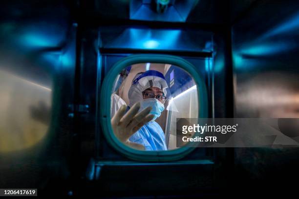 Medical staff member gestures inside an isolation ward at Red Cross Hospital in Wuhan in China's central Hubei province on March 10, 2020. - Chinese...