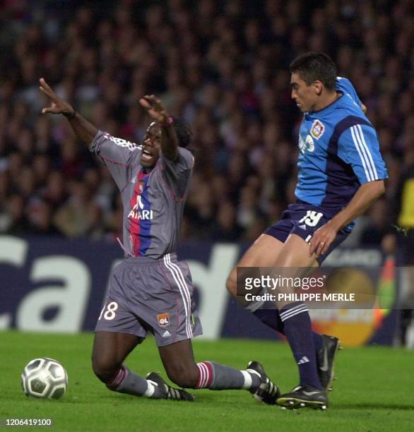 L'attaquant lyonnais Pegguy Luyindula est taclé par le défenseur de Leverkusen Lucio, le 18 septembre 2001 au stade de Gerland à Lyon, lors du match...
