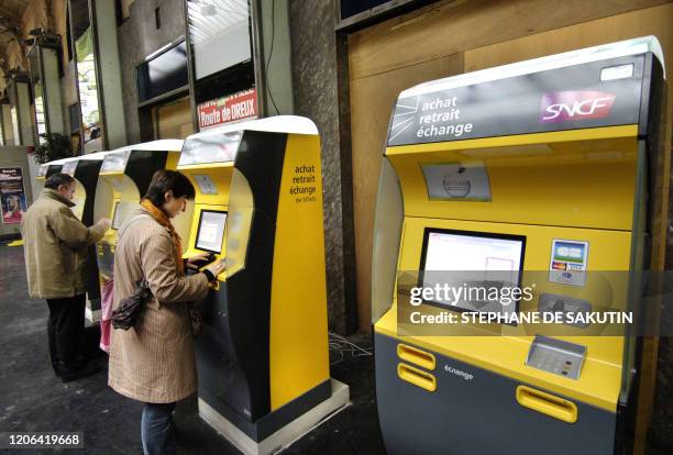 Des usagers utilisent un distributeur automatique de billets de la SNCF à la gare Saint-Lazare à Paris, le 09 novembre 2005, alors les guichetiers et...