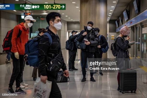 Travelers are seen wearing facemasks as protection from COVID-19 inside Incheon International Airport on March 10, 2020 in Incheon, South Korea....