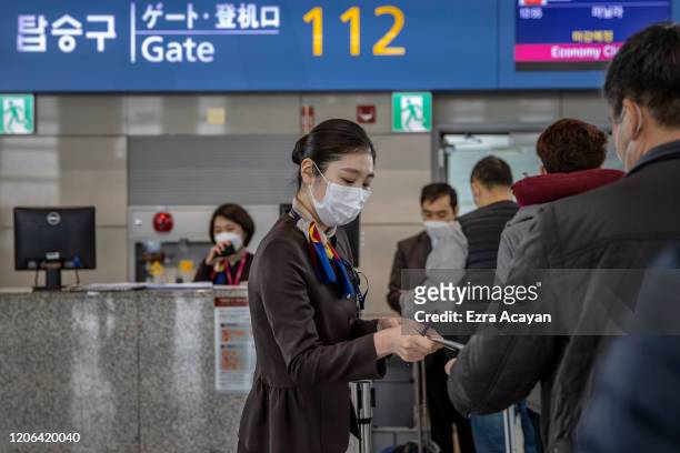Airport staff are seen wearing facemasks to protect themselves from COVID-19 inside Incheon International Airport on March 10, 2020 in Incheon, South...