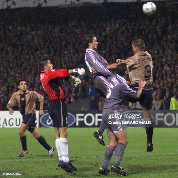 Le gardien lyonnais Grégory Coupet est à la lutte avec le défenseur espagnol Frank de Boer , le 23 octobre 2001 au stade de Gerland à Lyon, lors de...