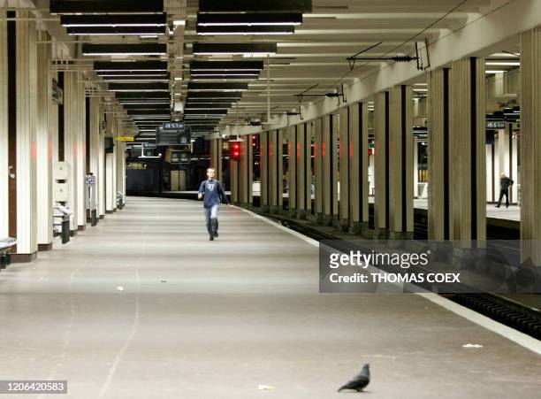 Un usager de la SNCF marche au milieu d'une voie vide à la gare du Nord à Paris alors qu'un mouvement de grève débute ce soir à 20 heures, à la...