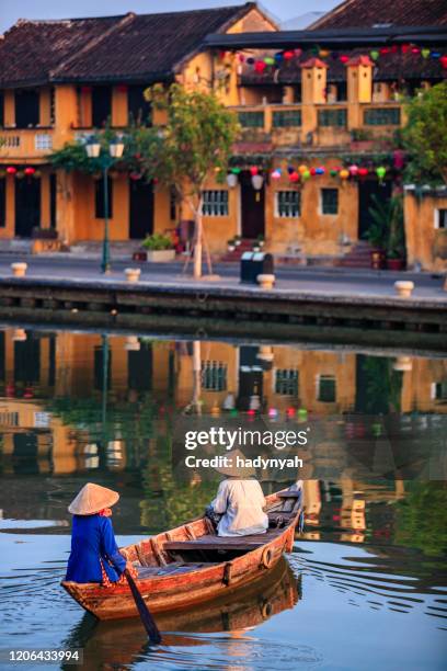 vietnamese vrouwen die een boot, oude stad in hoi an stad, vietnam berijden - hoi an stockfoto's en -beelden