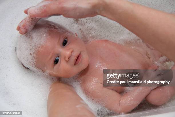 baby having bath - mother and baby taking a bath stock-fotos und bilder