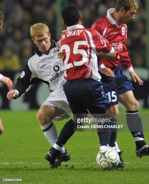 Le milieu de terrain Lillois Sylvain N'diaye et son coéquipier, l'attaquant Djezon Boutoille , tente de contrer le joueur de Manchester United Paul...