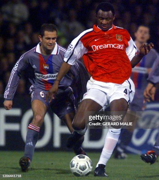 Le milieu de terrain français de l'Arsenal Patrick Vieira devance le joueur de Lyon Philippe Violeau , le 13 février 2001 au stade de Gerland à Lyon,...