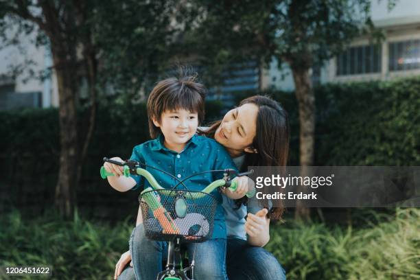 cute son with mother for bicycle time at the garden - asian cycling stock pictures, royalty-free photos & images