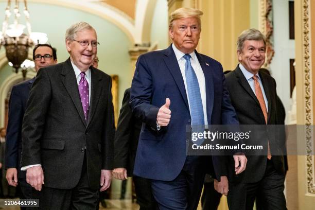 President Donald Trump arrives at the US Capitol to attend the Republicans weekly policy luncheon on March 10, 2020 in Washington, DC. He is flanked...