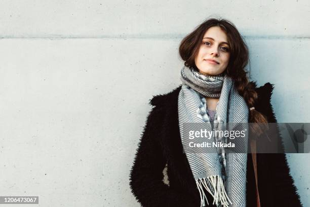 het jonge portret van de vrouw tegen grijze muur - berlin wall fall stockfoto's en -beelden
