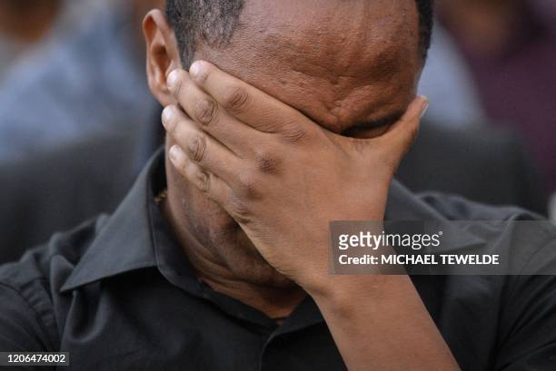 Man covers his face with his hand as he attends a commemoration ceremony held by the Airline Pilots' Association of Ethiopia on the first anniversary...