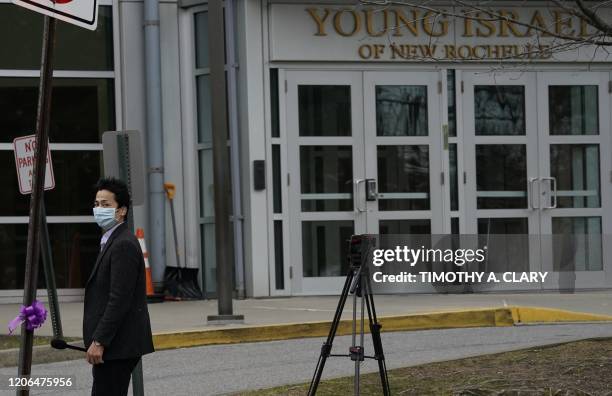 Members of the media wearing protective mask film outside the Young Israel of New Rochelle synagogue, New York on March 10 at the center of a...