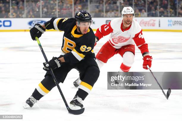 Brad Marchand of the Boston Bruins skates past Luke Glendening of the Detroit Red Wings during the first period at TD Garden on February 15, 2020 in...
