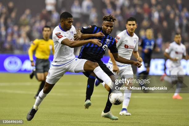 Elvin Oliva of CD Olimpia competes for the ball with Orji Okwonkwo of the Montreal Impact in the second half during the 1st leg of the CONCACAF...