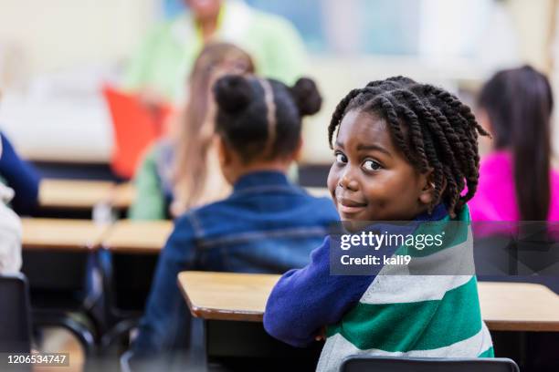 african-american boy in elementary school classroom - boy looking over shoulder stock pictures, royalty-free photos & images