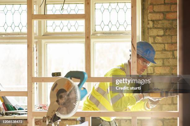 young carpenter fixing studwork - table saw stock pictures, royalty-free photos & images