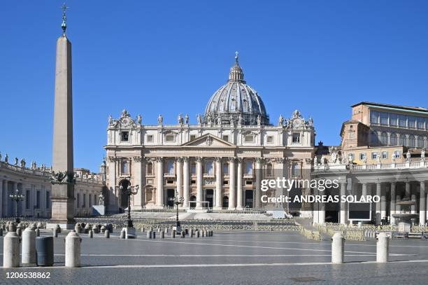 General view taken on March 11, 2020 shows the Vatican's deserted Saint Peter's Square and its main basilica a day after they were closed to tourists...