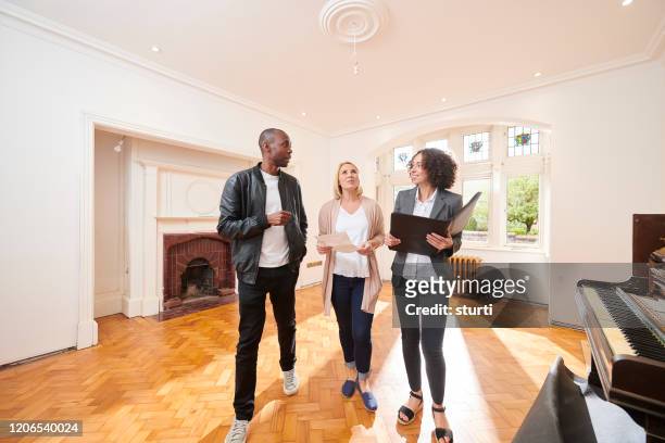 househunt couple with agent - real estate agent stock pictures, royalty-free photos & images