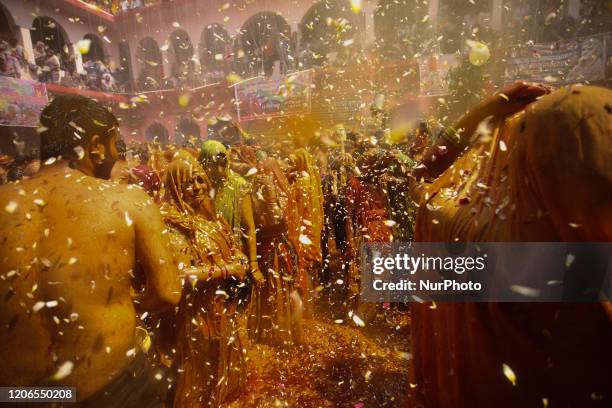 Men and women take part in Huranga, a game played between men and women a day after Holi, at Dauji temple near the northern city of Mathura, India...