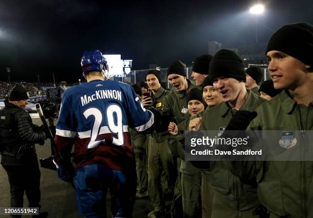 Nathan MacKinnon of the Colorado Avalanche fist bumps with Air Force cadets en route back to the ice for the second period of the 2020 NHL Stadium...