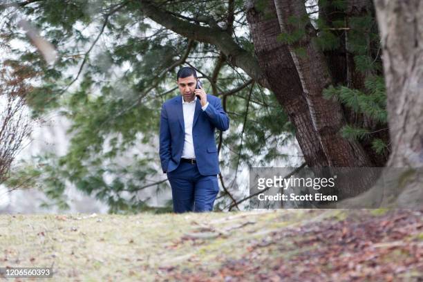 Campaign manger for Democratic presidential candidate Sen. Bernie Sanders , Faiz Shakir, talks on a cell phone outside of Sanders' home prior to a...