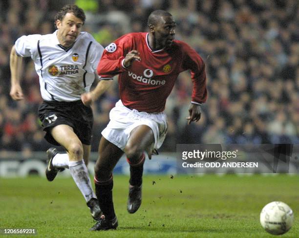 Manchester United`s forward Andy Cole runs with the ball pursued by Valencia`s Amedeo Carboni during their Champions League match at Old Trafford...