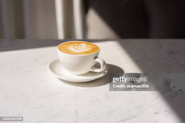 close up cappuccino cup with lighting and copy space - coffee table cafe stock-fotos und bilder