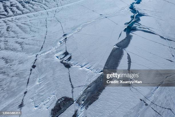 cracks in ice lake - drijfijs stockfoto's en -beelden