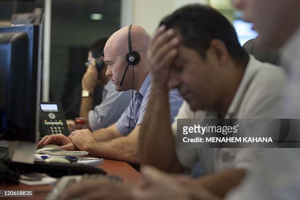 Israeli stock market traders work at their office in the Meitav investment house in Tel Aviv on August 8, 2011 a day after key Israeli stock indices...