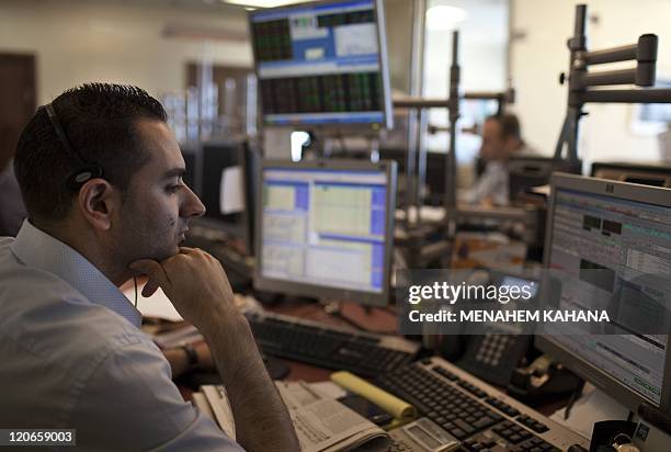 Israeli stock market traders work at their office in the Meitav investment house in Tel Aviv on August 8, 2011 a day after key Israeli stock indices...