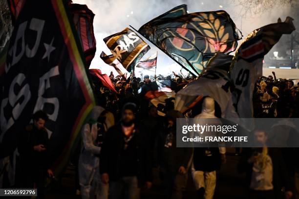 Supporters wave flag and chant slogans as they arrive to attend the UEFA Champions League round of 16 second leg football match between Paris...