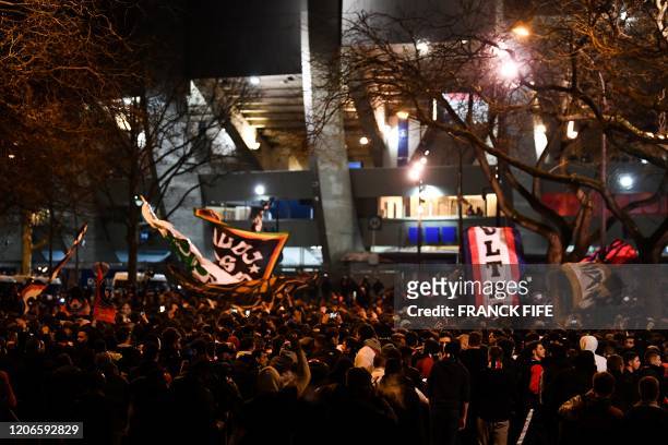 Supporters wave flags and chant slogans outside the Parc des Princes stadium ahead of the UEFA Champions League round of 16 second leg football match...