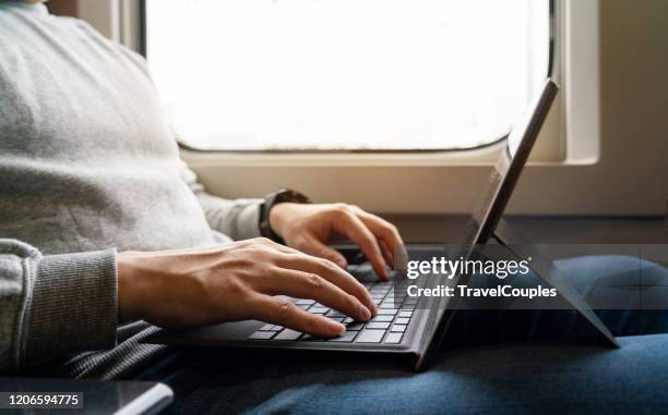 businessman on train working on laptop computer. freelancer men in white sweater working with laptop in the train. business travel or technology concept. - working on laptop in train top view imagens e fotografias de stock