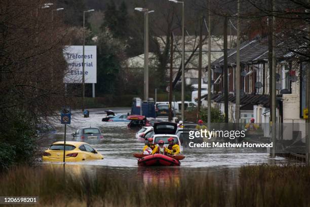 Woman is rescued from a property on Oxford Street on February 16, 2020 in Nantgarw, Wales.The Met Office have issued a red weather warning for rain...